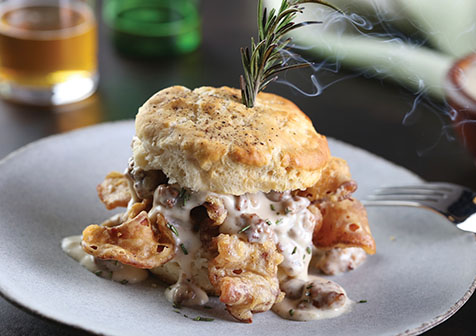 chicken fried bacon biscuit on grey plate